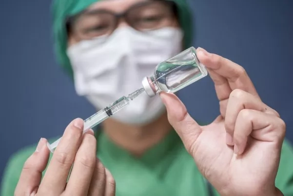 Anaesthetist preparing to administer epidural injection.